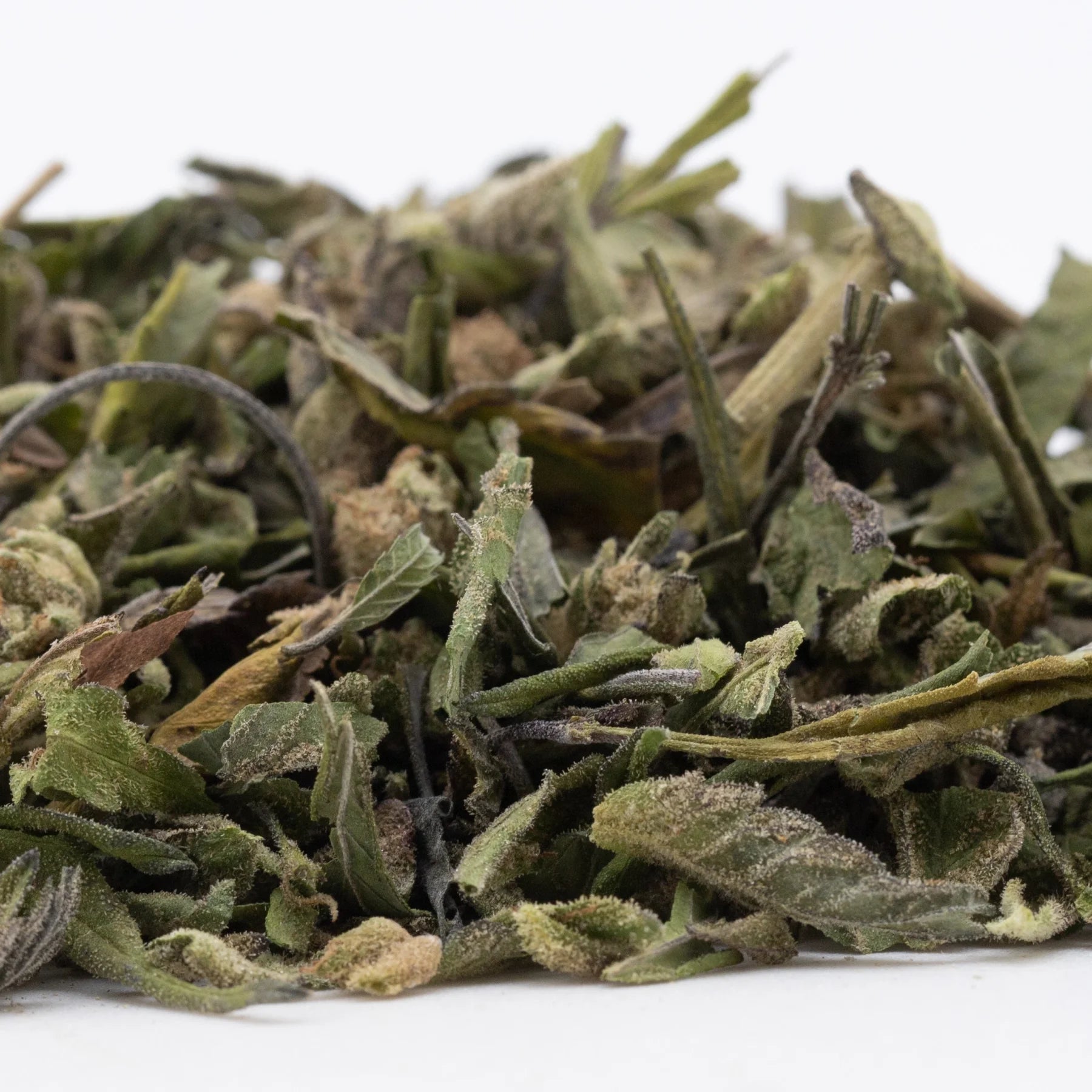 Dried bahama bussdown greenhouse thca trim with fuzzy white tea leaves in green and brown hues for hemp flower use