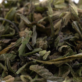 A pile of dried light green and pale yellow bahama bussdown hemp flower greenhouse thca trim with fuzzy texture