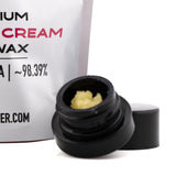 Black plastic jar containing yellowish textured banana cream 98.39 percent thca dab wax for sativa excellence