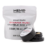 Black cylindrical container with matching lid holding light-colored banana kush thca crumble wax 5 gram hemp flower