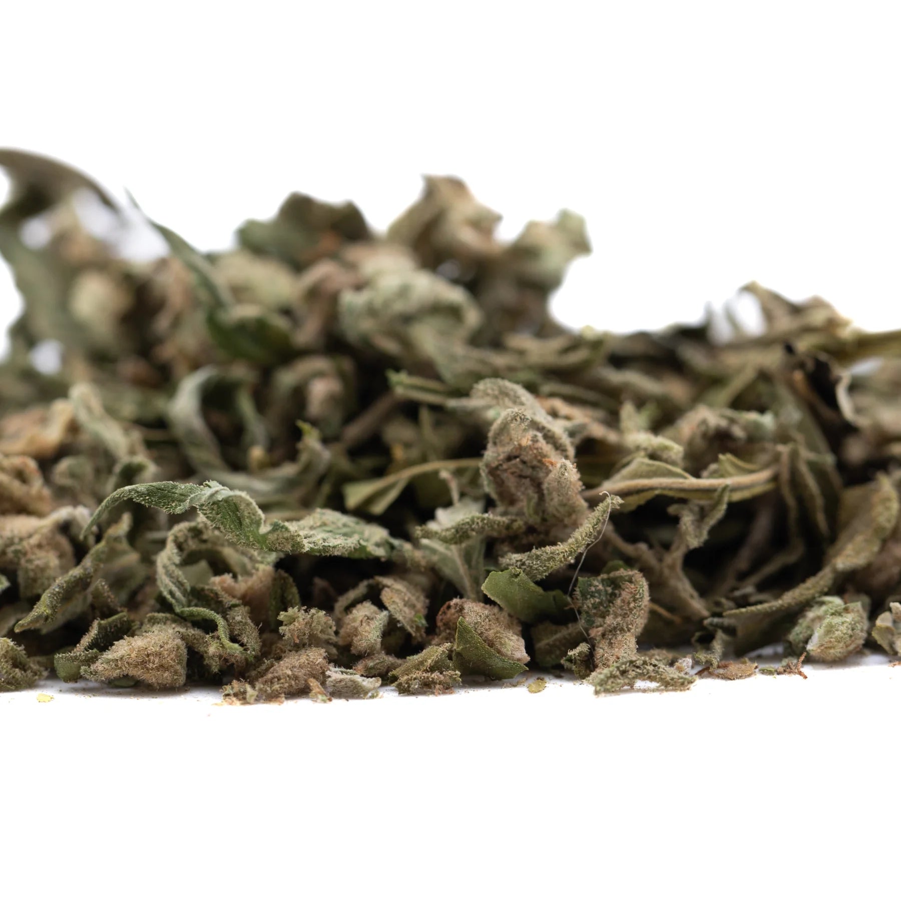 A pile of dried banana og full-term thca shake trim leaves with muted green and brown hues showing cannabinoid content