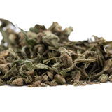A pile of dried banana og full-term thca shake trim leaves with muted green and brown hues showing cannabinoid content