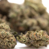 Dense green and orange-hued banana og’s full-term thca hemp flower buds with a textured surface in smalls size