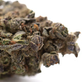 Dense resinous banjerine thca flower bud with green and purplish hues covered in trichomes for evening stress relief