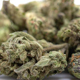 Dense green banjerine thca flower smalls with frosty white trichomes and orange pistils ultra-premium citrus indica