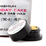 Black cylindrical container with white label holding yellowish birthday cake thca crumble wax 5 gram for hemp flower use