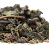 A pile of dried greenish-brown blue sugar’s greenhouse thca trim leaves with fuzzy textures and stems for sugar cookies