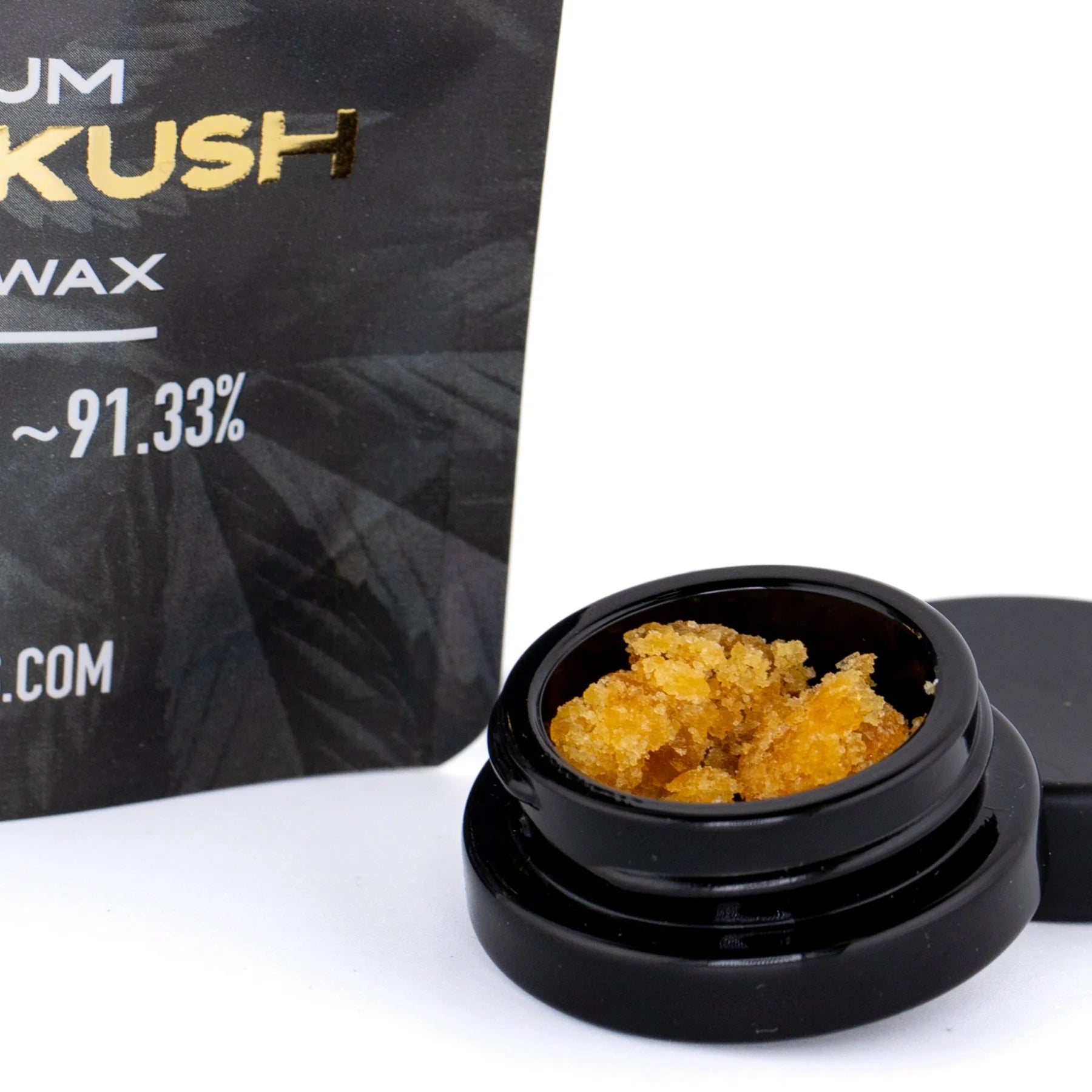 Black ceramic jar filled with golden-orange bubba kush cbd dab wax 1g for pre-98 bubba kush concentrate use