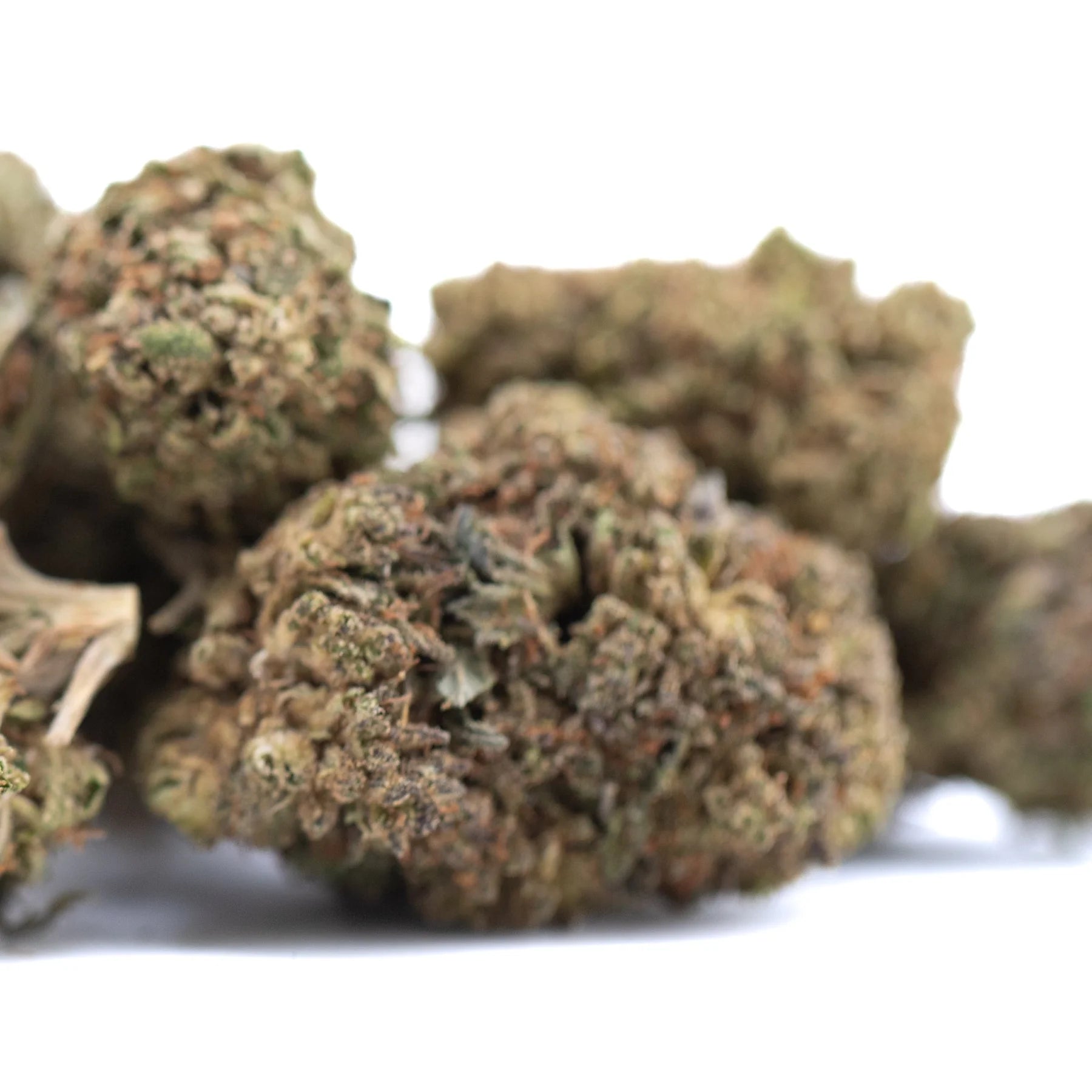 Dense bubba kush cbd full-term hemp flower buds with green brown and orange hues and textured surface