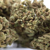 A dense green bubba kush full-term hemp flower bud with fine trichomes and subtle brown hints afghani indica strain