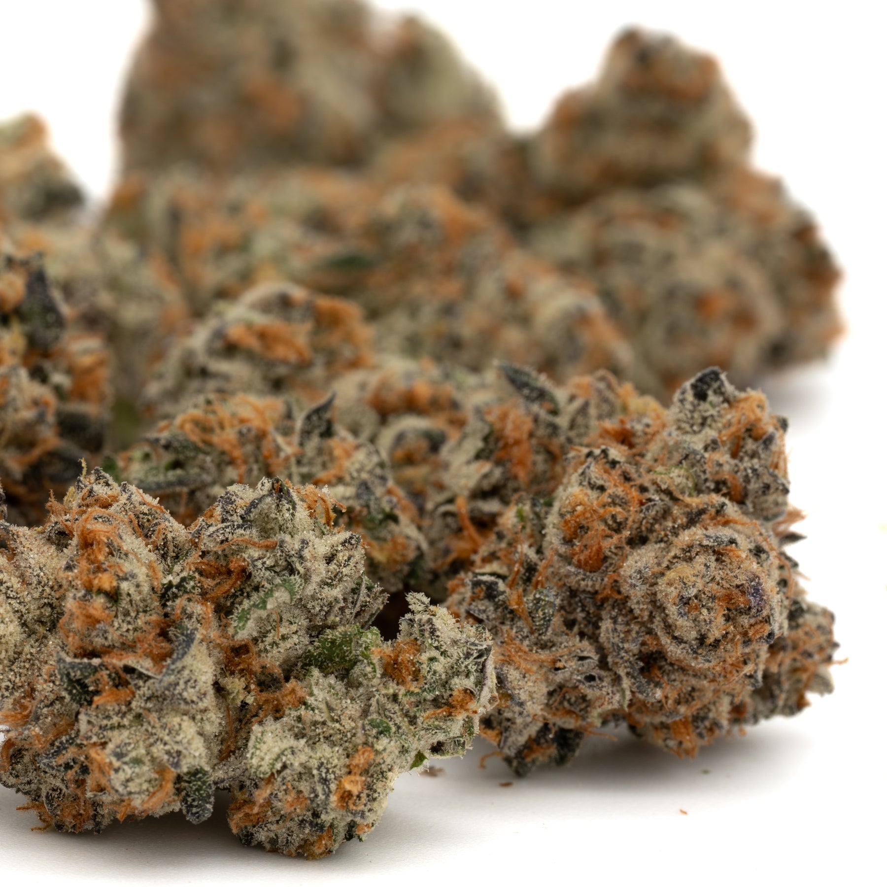 Cadillac Rainbow THCa flower with dried cannabis buds, orange hairs, and frosty coating