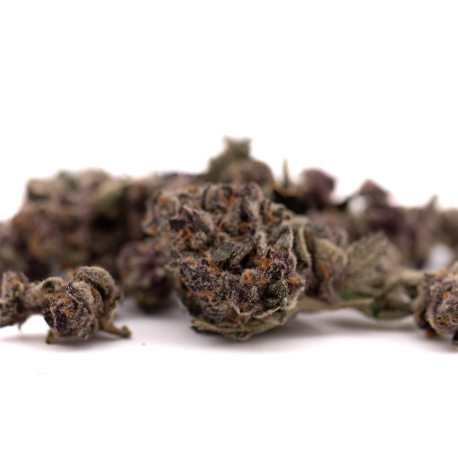 Pile of dried Candy Mac THCa Indoor cannabis buds with purple hues and trichomes