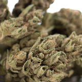 Cbg hemp flower smalls featuring a dense green bud with frosty white trichomes and orange pistils