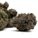 Dense indoor THCa cannabis bud with orange hairs labeled PREMIUM INDOOR for Chunky Monkey Indoor THCa Flower