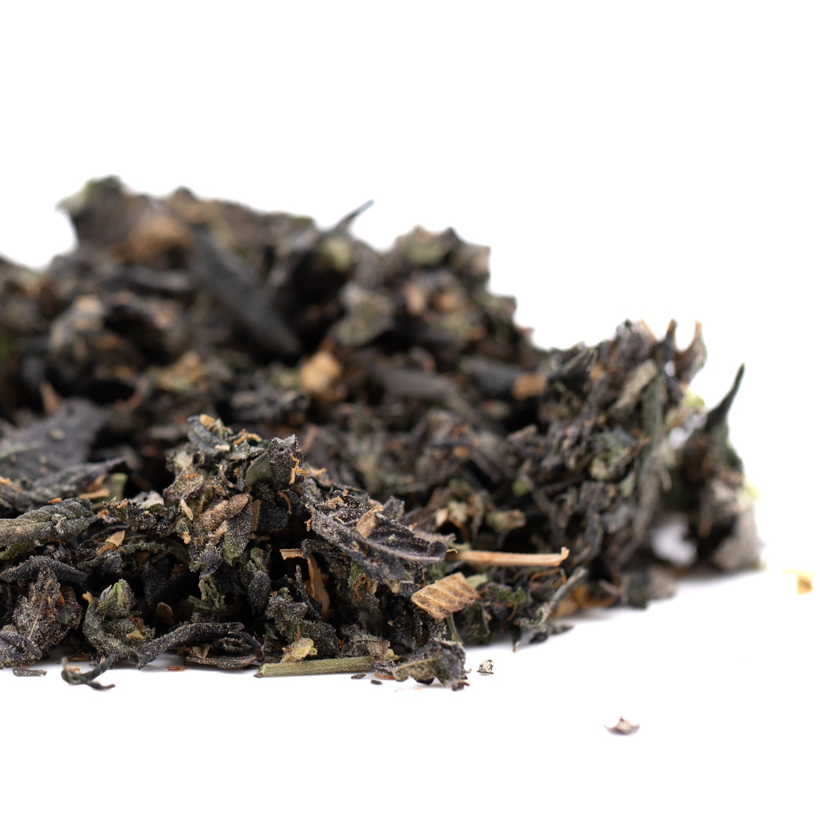 Pile of loose leaf black tea with dried leaves and stems for Chunky Monkey Indoor Trim Wholesale 1LB featuring grape ape, thca trim, and banana kush