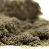 A mound of fine dark gray cream caramel thca kief with granular texture from hemp flower product full-term