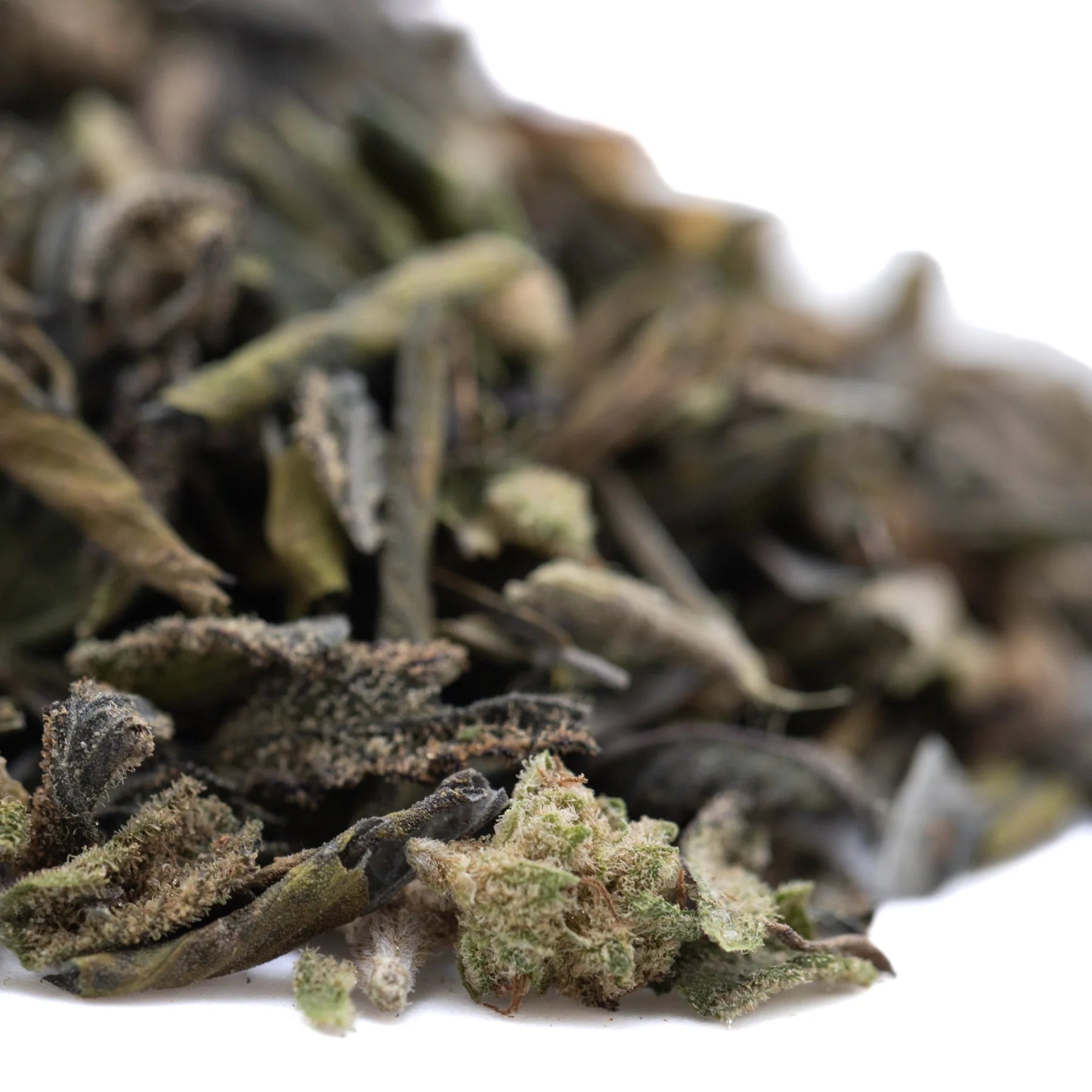 Dried deep space greenhouse thca trim with dark and light green deep chunk leaves featuring fuzzy texture and sedative effects