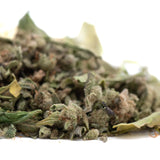 A pile of durban poison full-term thca trim dried cannabis buds with green and brown hues covered in dense trichomes