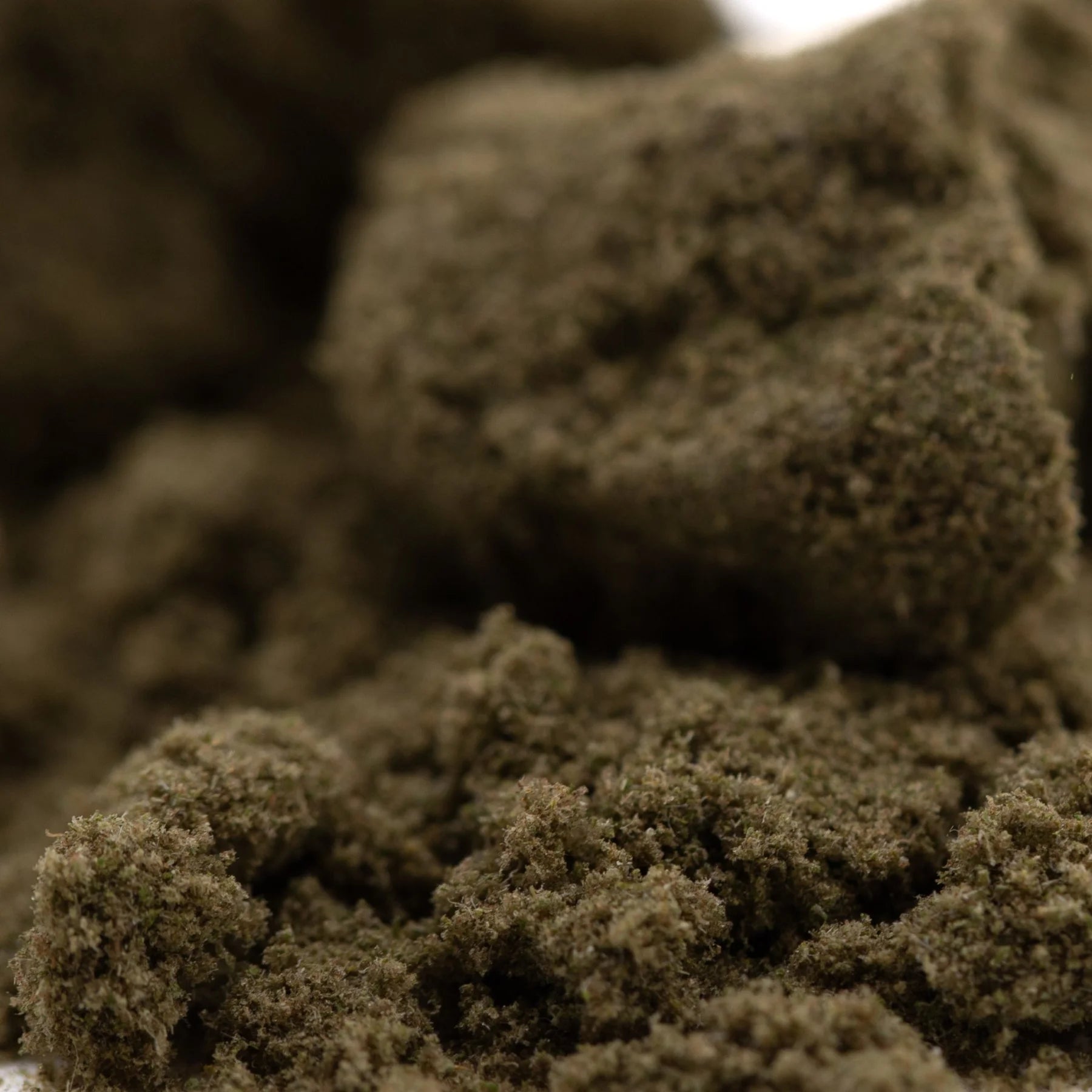 Dark brown textured mossy clumps of durban poison thca kief for living cannabis extraction and use