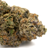 Close-up of Burmese Kush cannabis bud with vibrant green and purple hues, orange pistils, and trichomes for Edible Panties Indoor THCa Flower