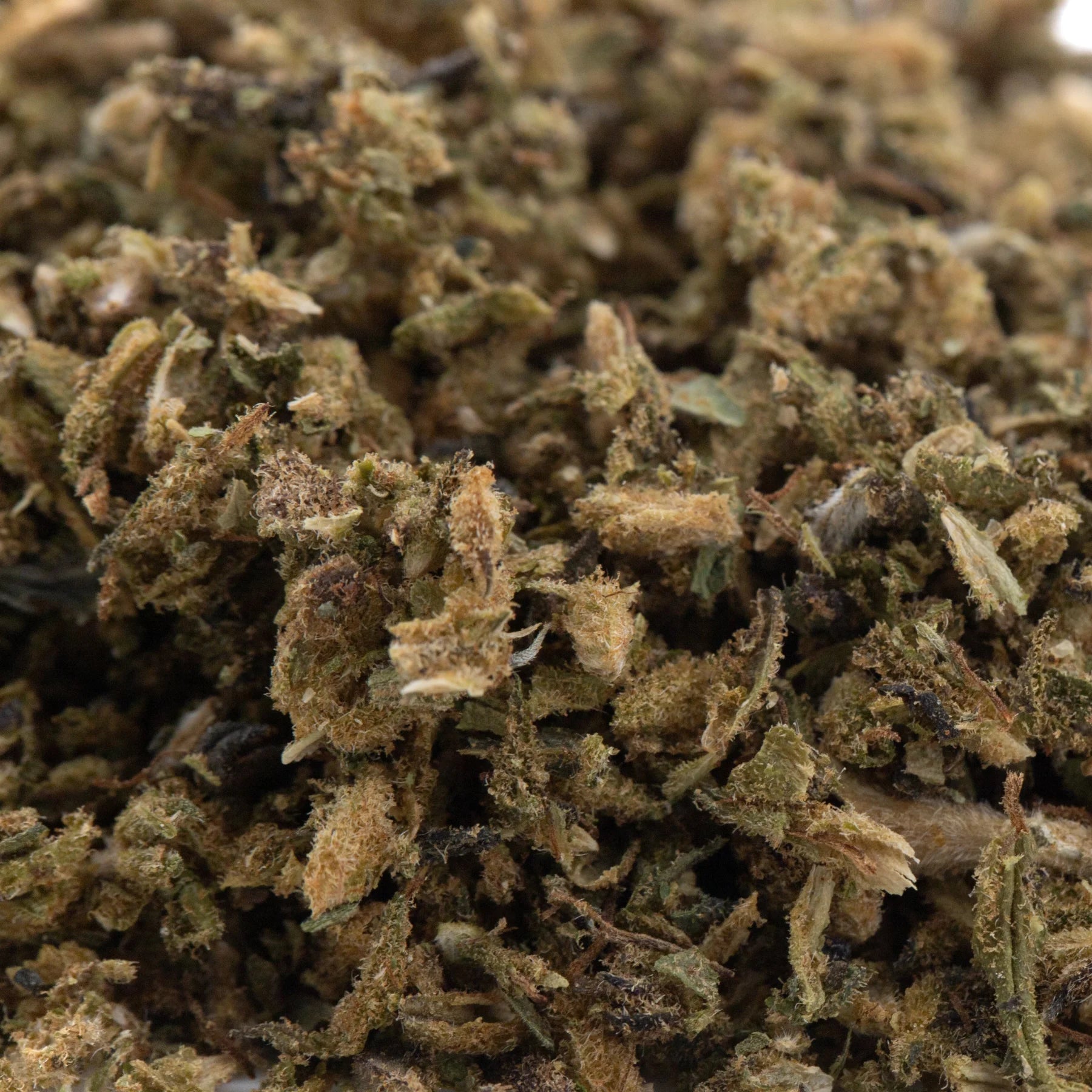A pile of green and brown elektra full-term cbd hemp flower trim showcasing a rich terpene profile and crumbly texture