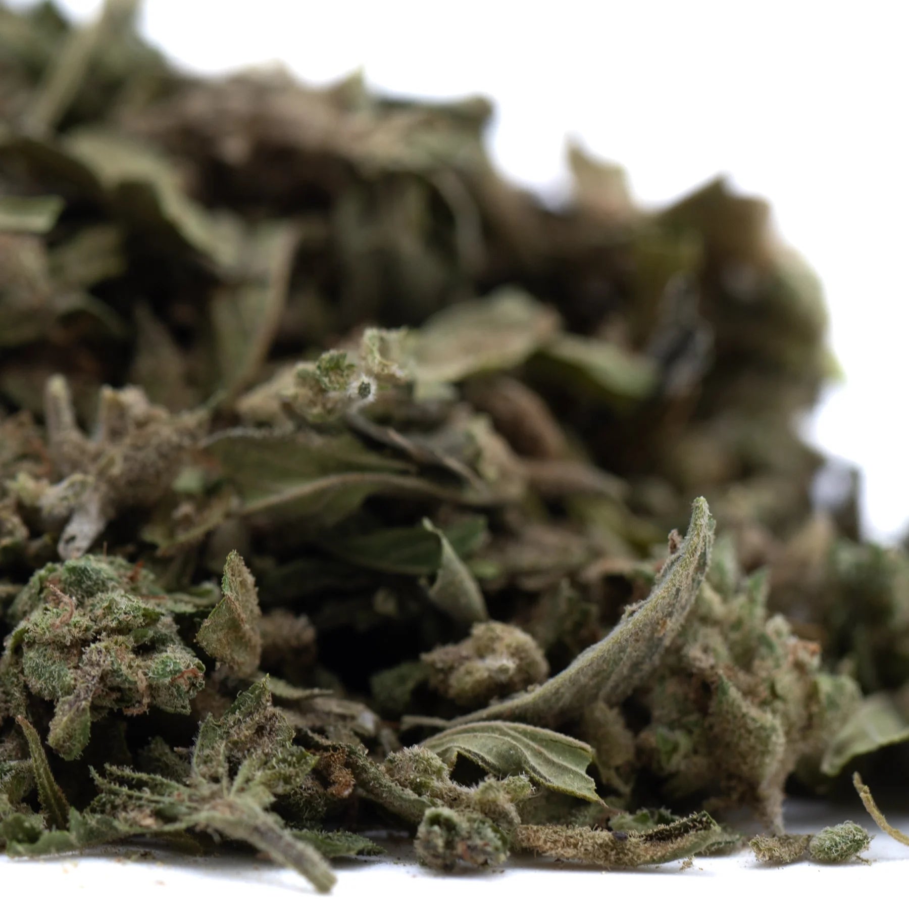 A pile of emerald fire’s premium full-term thca dried cannabis buds with green leaves and brownish trichomes
