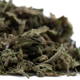 A pile of emerald fire’s premium full-term thca dried cannabis buds with green leaves and brownish trichomes