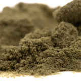 A mound of coarse olive-green thca kief full-term from dark heart nursery with a textured sour lemon-lime surface