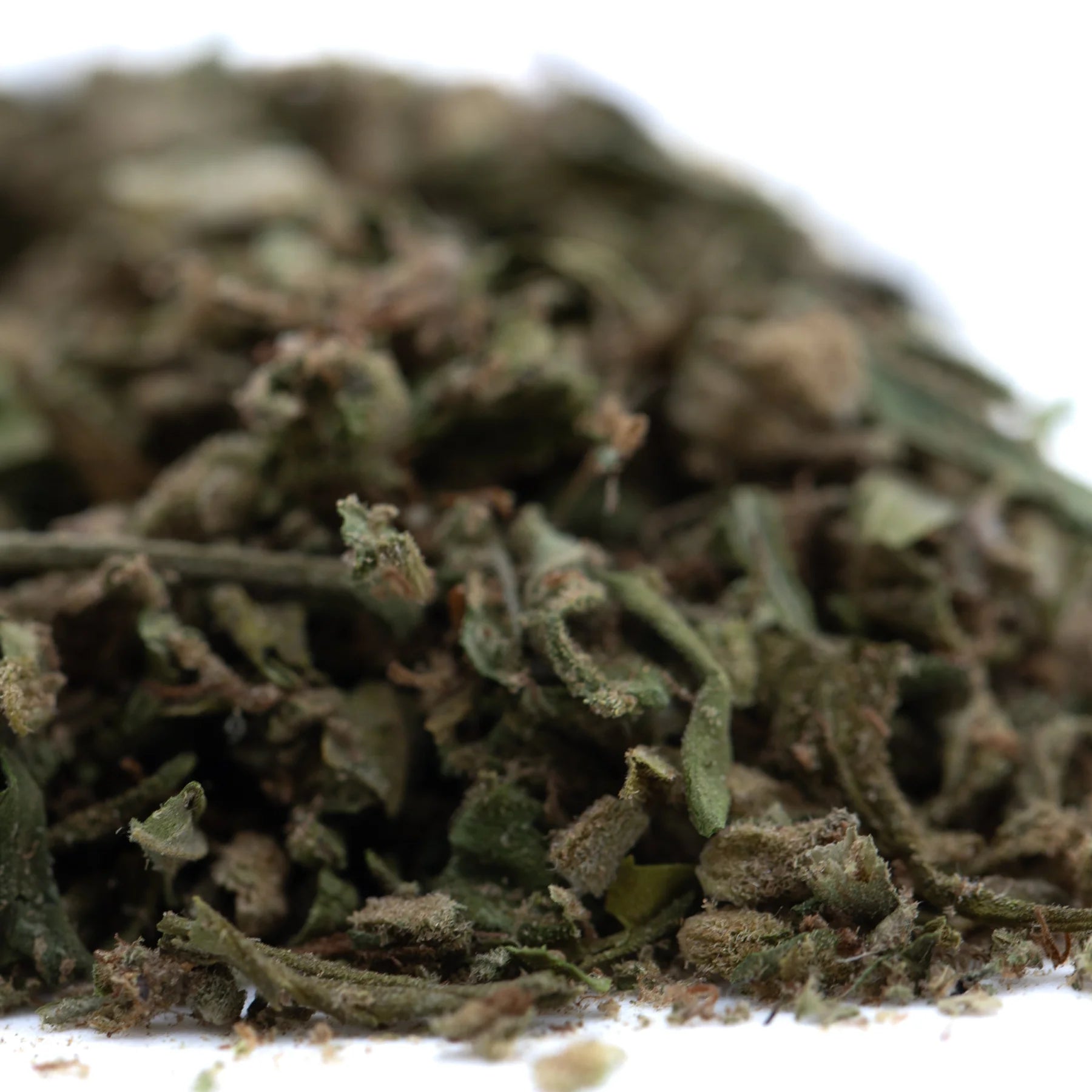 A pile of dried greenish-brown face fat full-term thca trim wholesale hemp flower leaves and buds