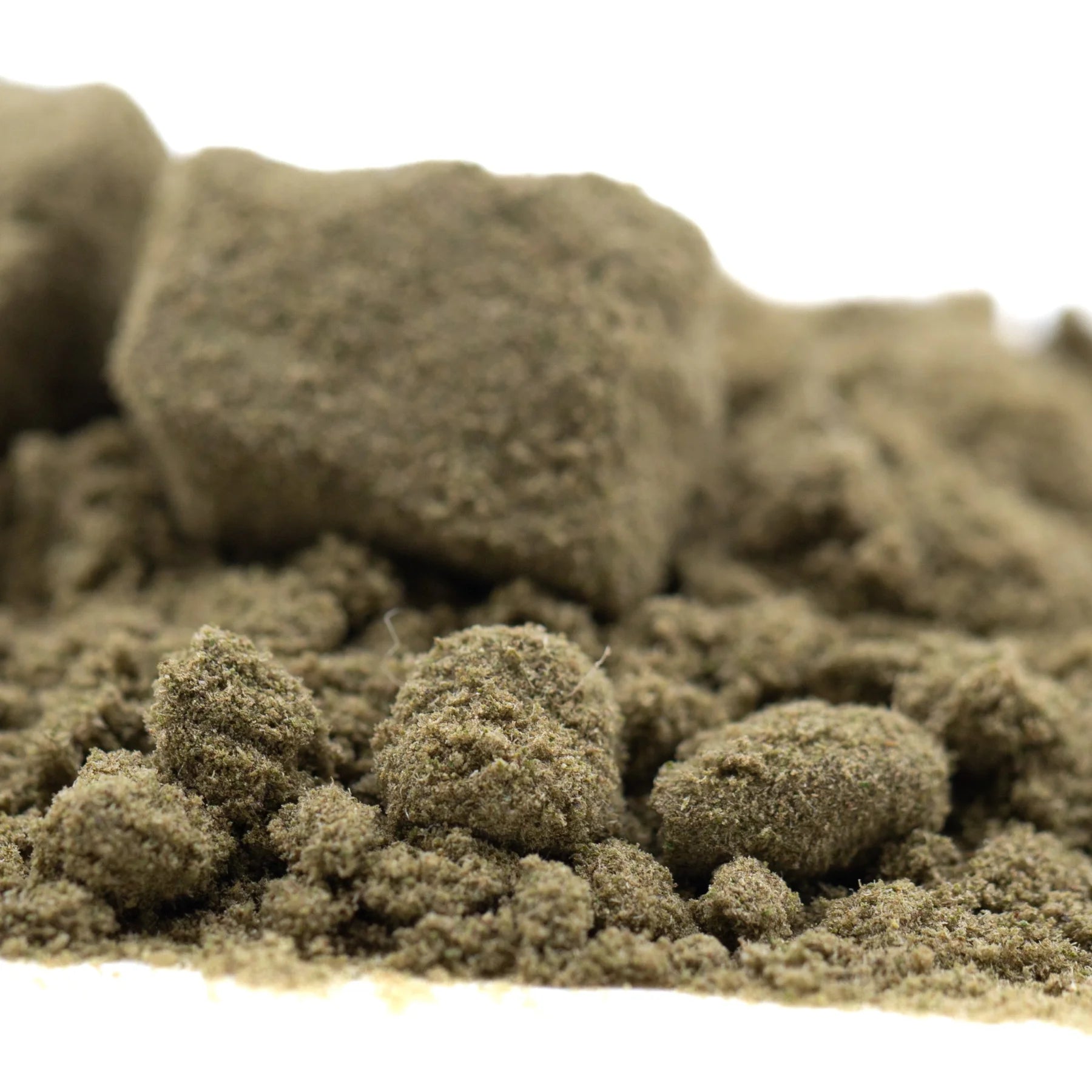 A mound of ultra-premium quantum thca kief coarse olive green sand with granular texture for face fat full-term use