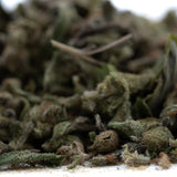 A close-up of fog dog thca trim hemp flower buds with green and brown hues covered in fine trichomes