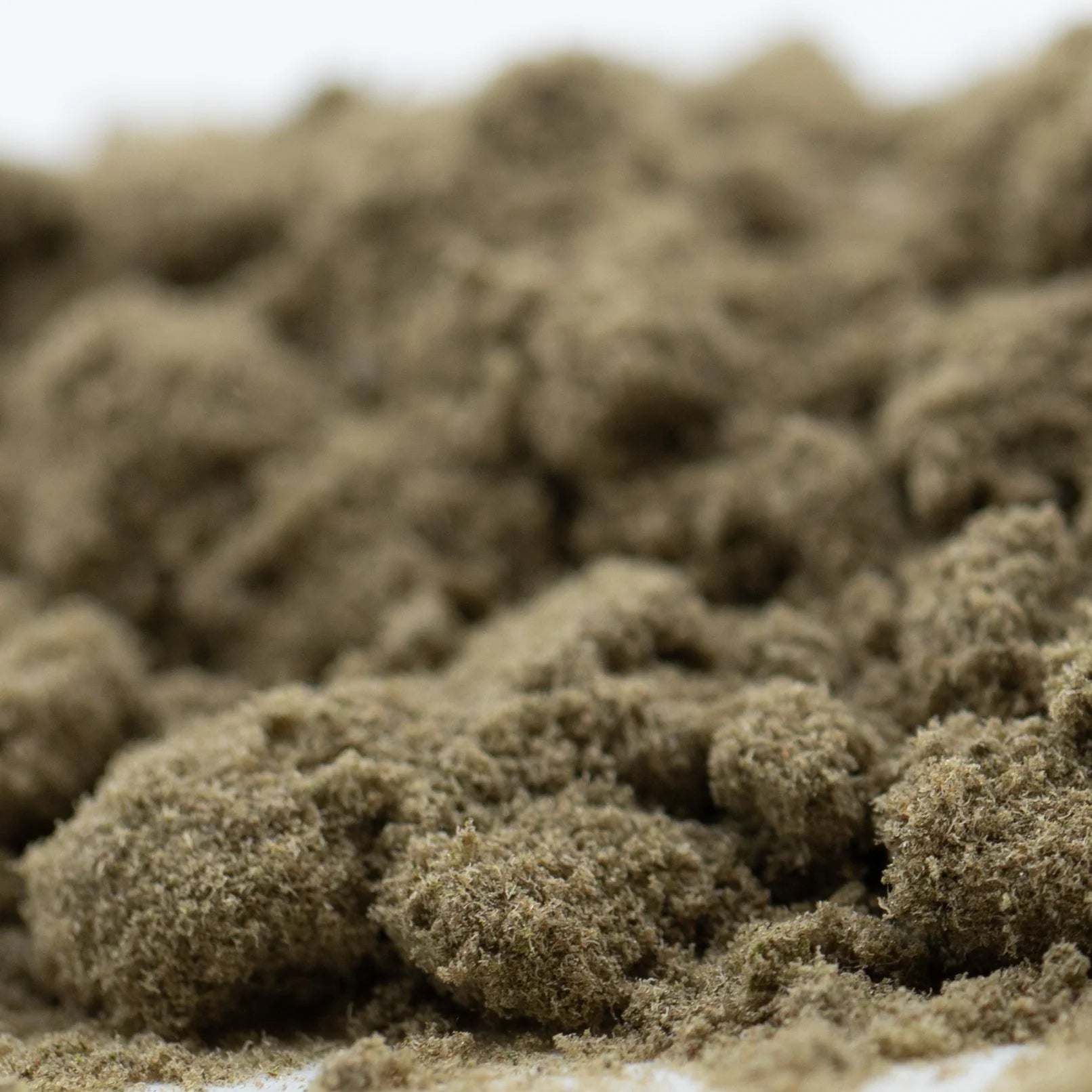 Bundled beige moss clusters showcasing fog dog kief hemp flower with textured fluffy appearance and concentrated potency