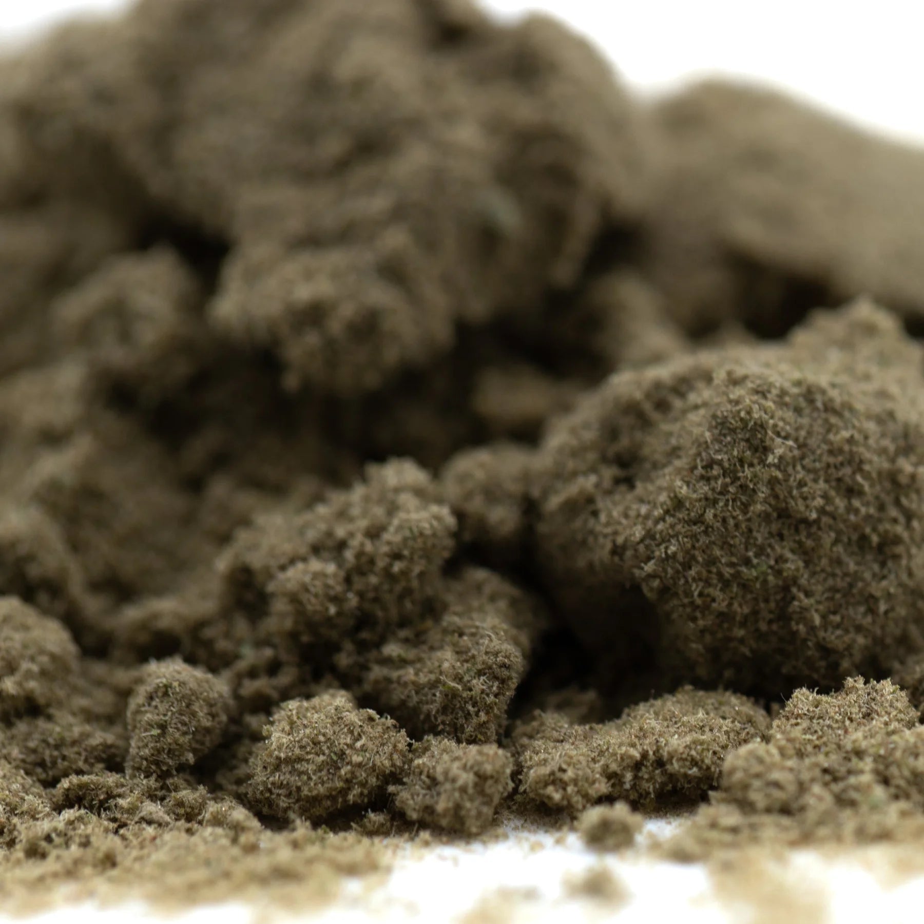 A mound of coarse dark brown fog dog kief with textured granular appearance showing concentrated potency from hemp flower
