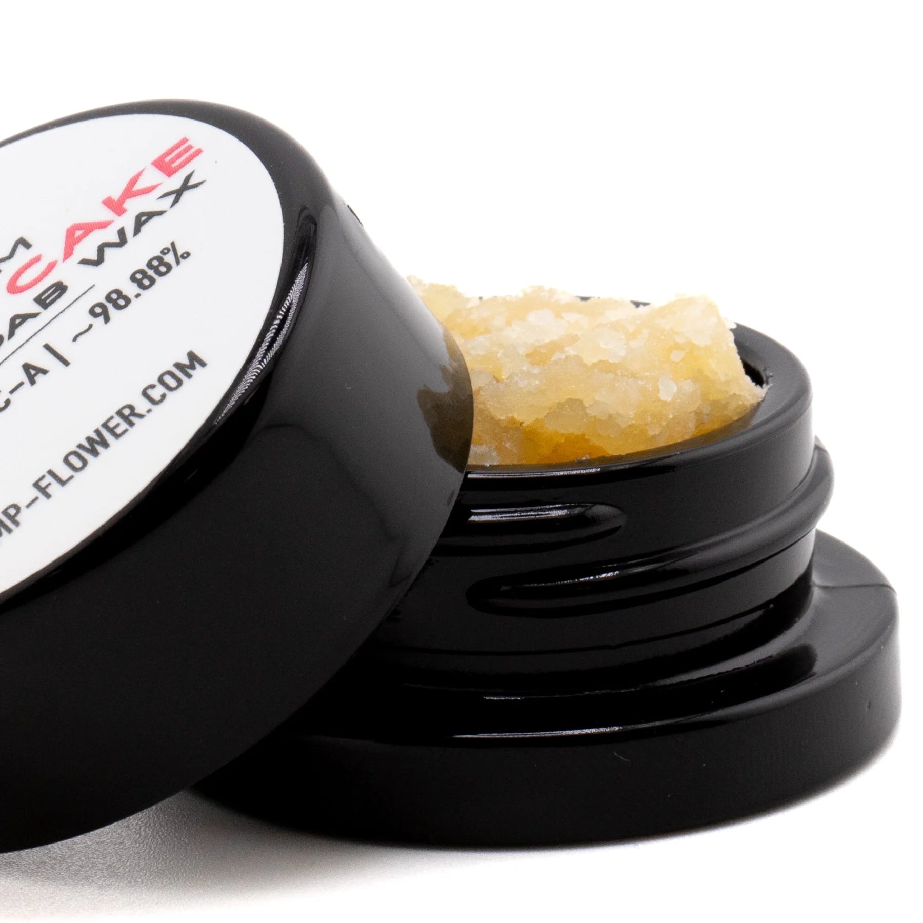 Black cylindrical container with white label holding amber gelato cake thca crumble wax for hemp flower use