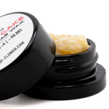 Black cylindrical container with white label holding amber gelato cake thca crumble wax for hemp flower use