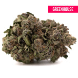 A dense greenhouse thca flower premium hemp bud with green and brown hues covered in fine trichomes makes giggle gas