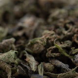 Dried green and brown chemdawg x gsc cannabis buds with visible trichomes in gmo full-term thca trim wholesale
