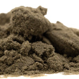 A mound of coarse dark gray kief with gritty texture from gmo thca kief full-term featuring legendary genetics and pungent garlic