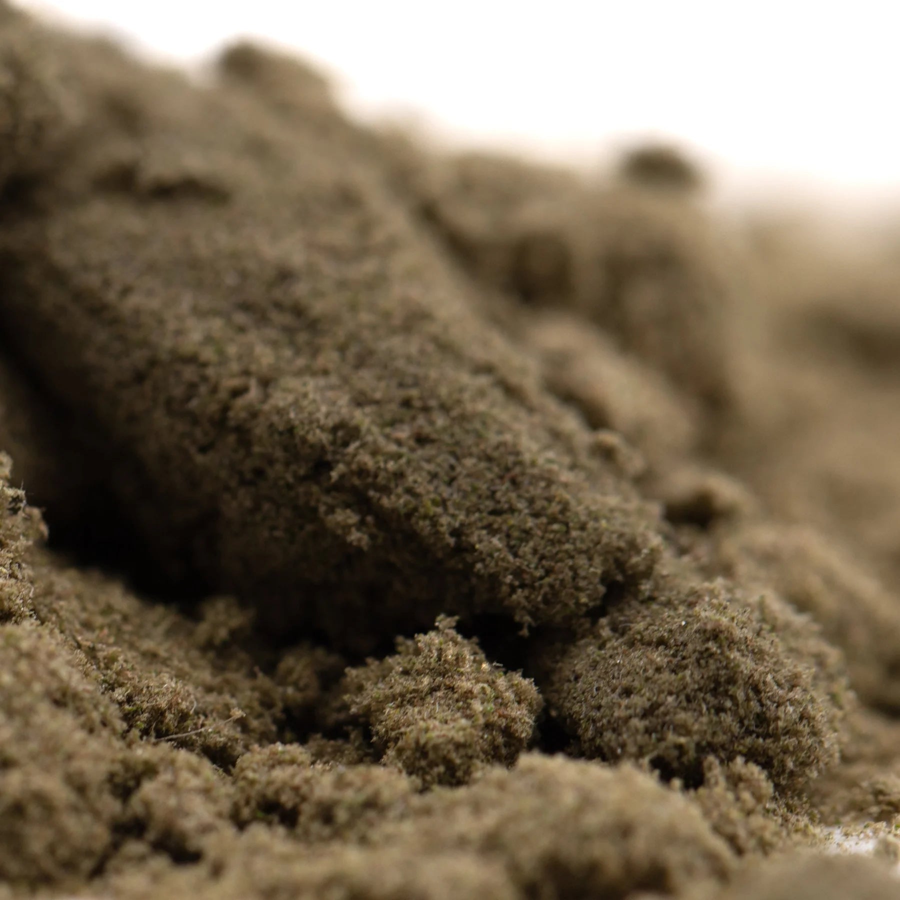 A mound of coarse earthy brown top-shelf indoor thca kief from garlic cookies cult for full-term wholesale use