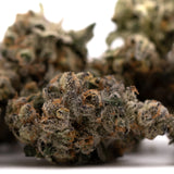 Dense trichome-covered Green Crack Indoor THCA flower with premium label and terpene profile analysis