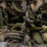 Dried halle berry greenhouse thca trim hemp flower with green and purple hues covered in dense trichomes