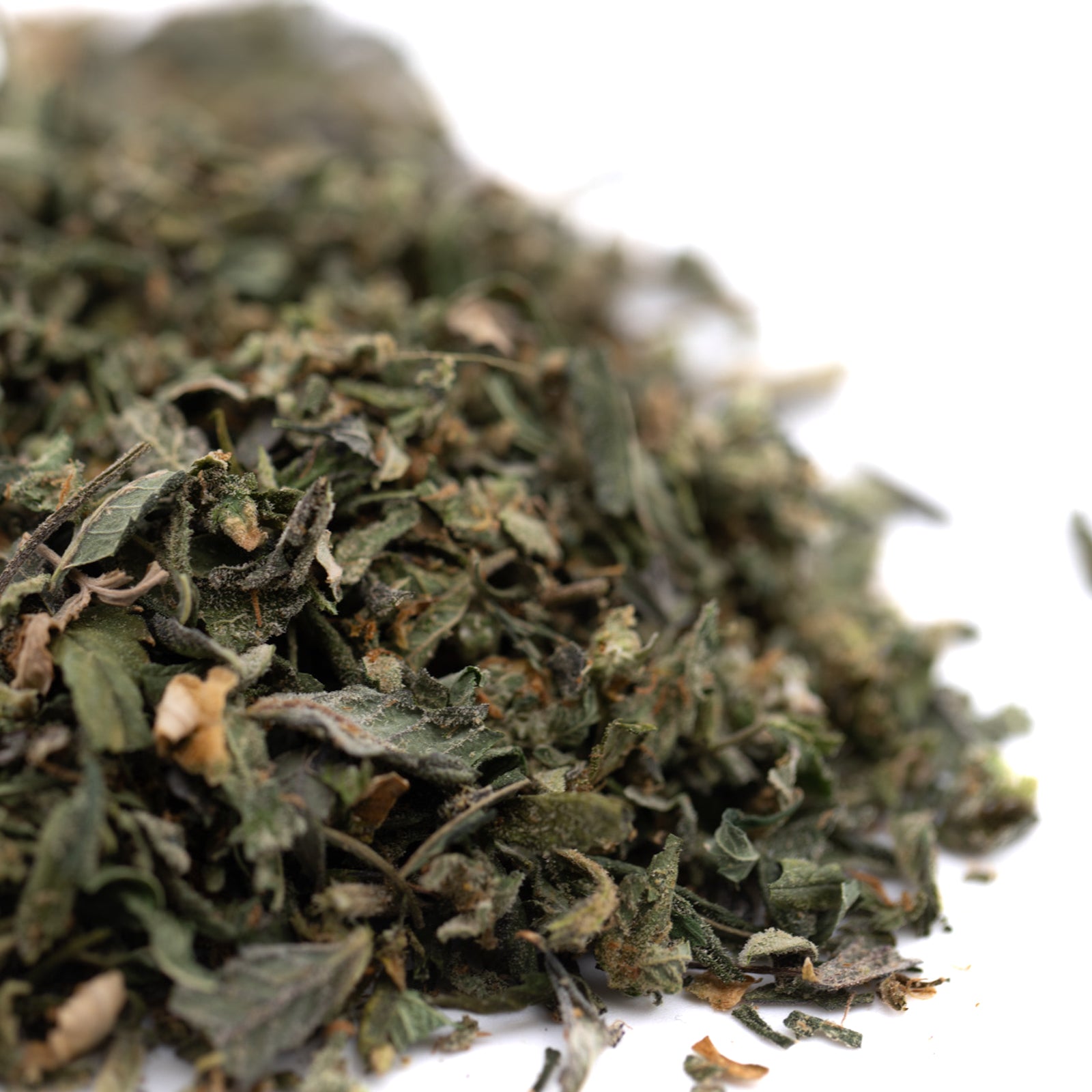 Dried crushed green herbs from Hooch Indoor THCa Trim Wholesale 1LB with trichome coverage