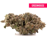A dense frosty hooch thca hemp flower with green and brown hues covered in trichomes from greenhouse thca
