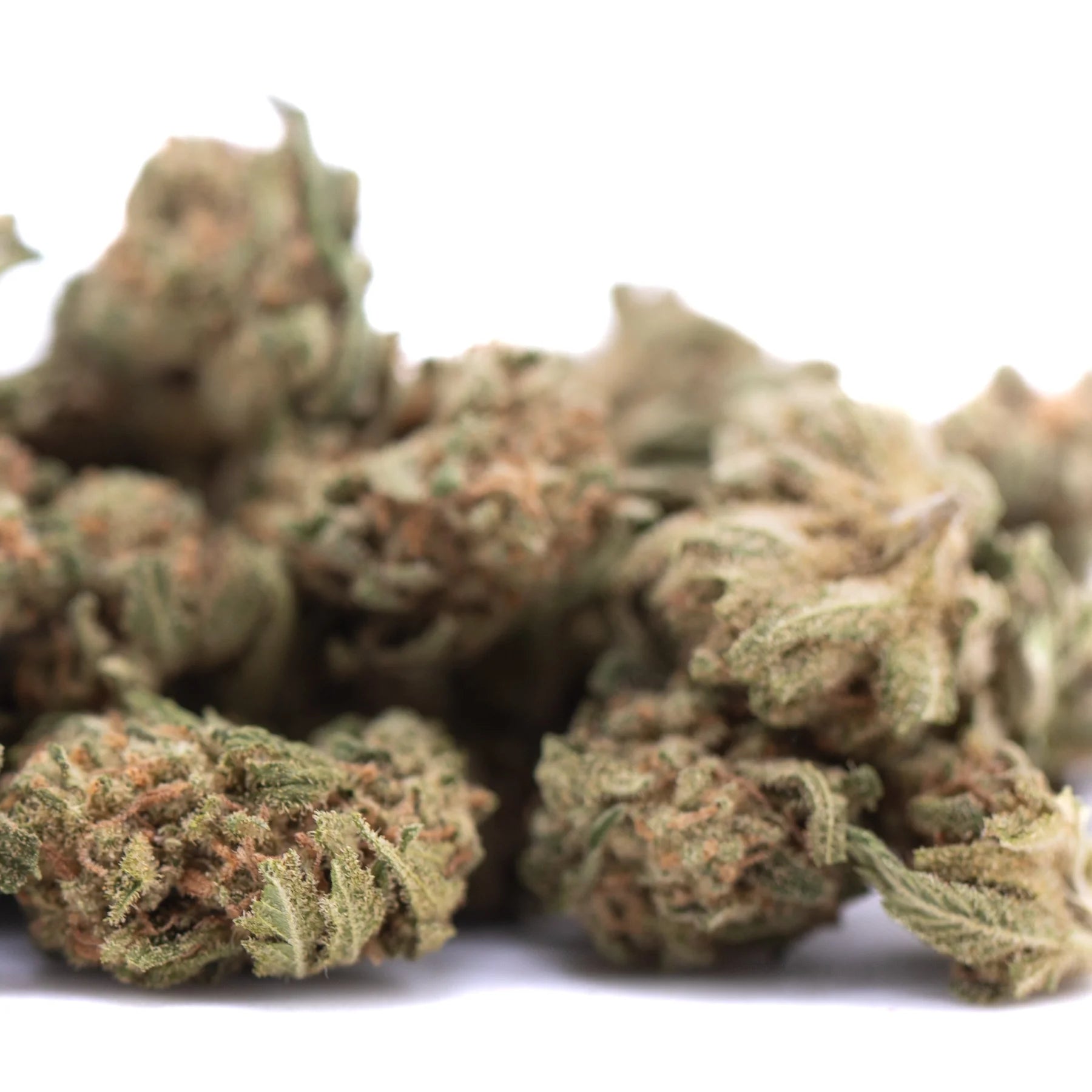 A pile of frosty green and brown humboldt dream thca flower buds from greenhouse smalls collection