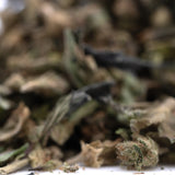 Dried green and brown full-term thca flower trim with textured leaves showcasing terpene profile from indoor cultivation