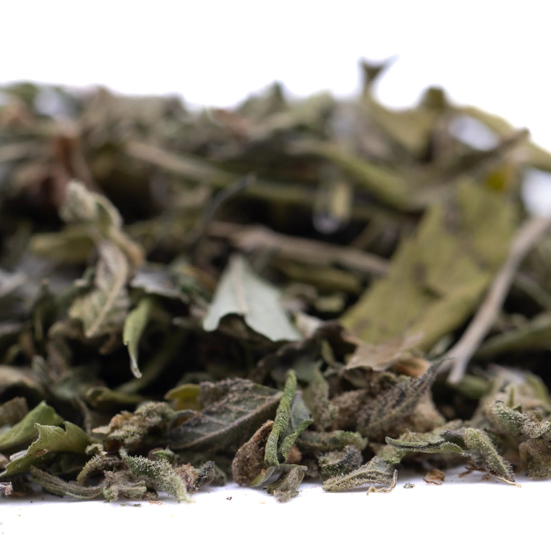 A pile of greenish-brown fuzzy jokerz nos greenhouse thca trim leaves ideal for jet fuel gelato and white runtz blends