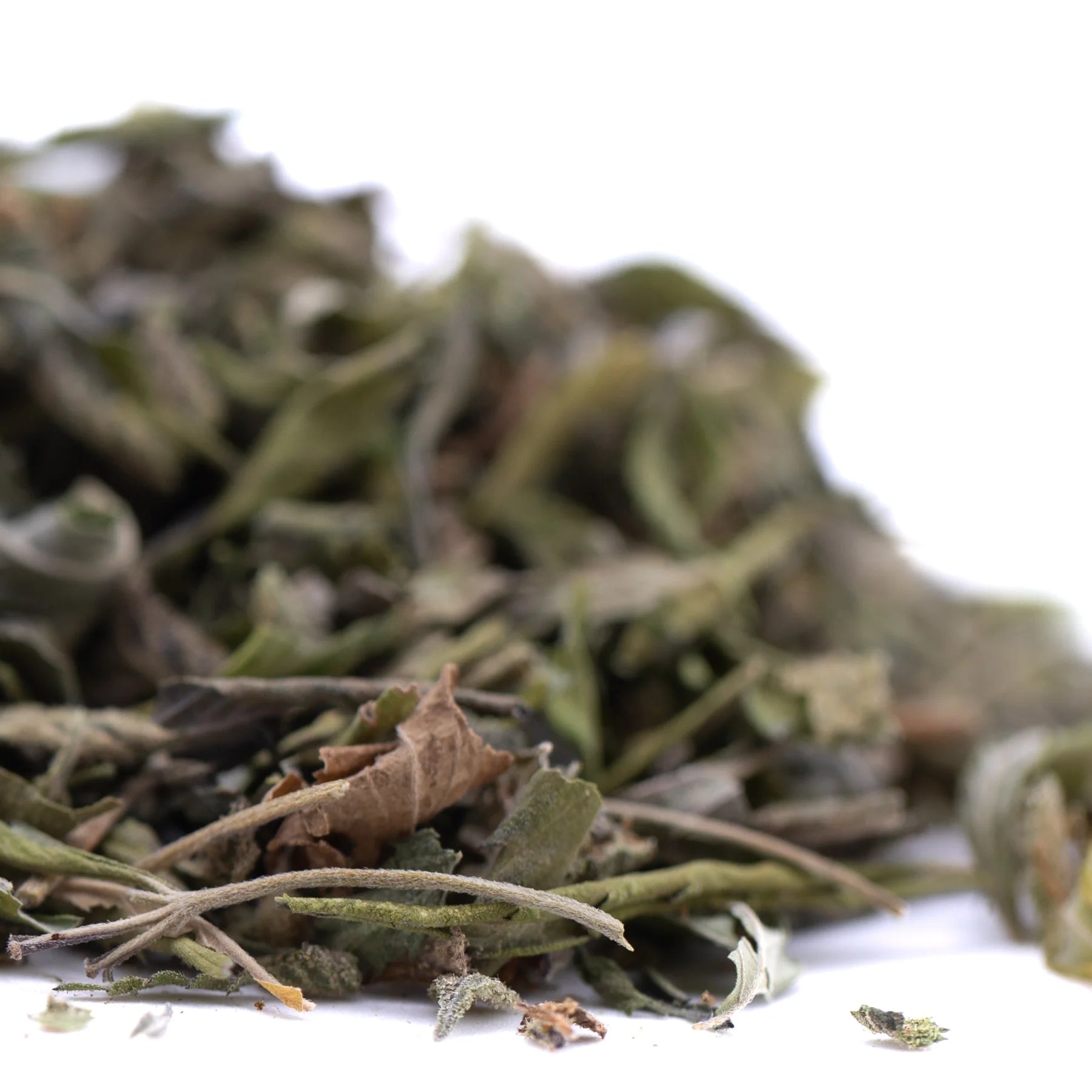 A pile of dried greenish gray greenhouse thca trim leaves and stems from jokerz nos for wholesale use