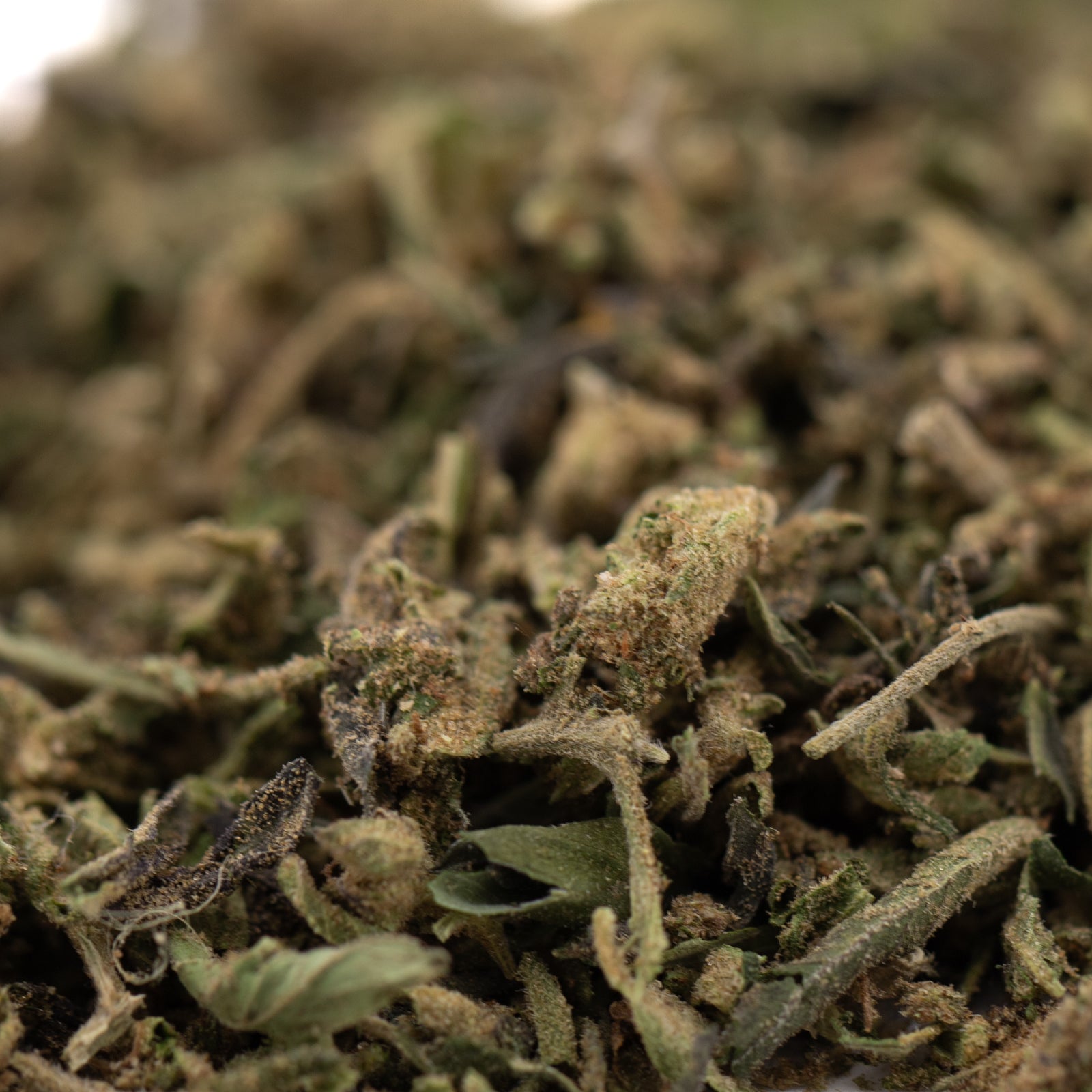 Jokerz THCa Trim Wholesale 1LB with dried ground cannabis, visible trichomes, white Runtz, Jet Fuel Gelato