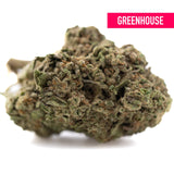 Dense green and brown lemon cherry gelato greenhouse thca flower bud covered in frosty trichomes with textured surface
