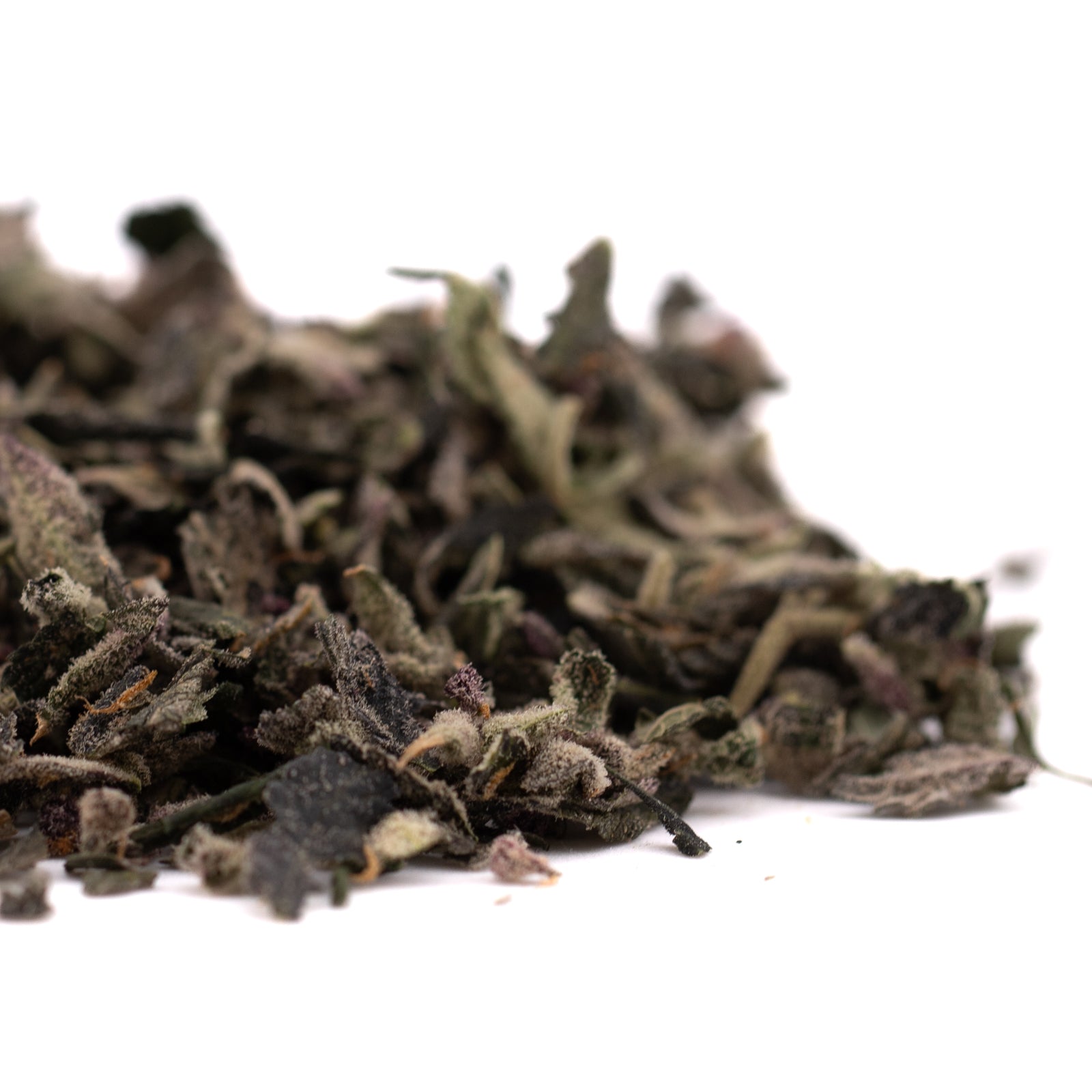 Dried loose-leaf tea with dark green and brown hues from Mac and Gary Indoor Trim Wholesale 1LB featuring thca trim and sugar leaves
